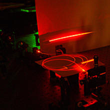 Laser light travels through an optical fiber, built at NIST, possessing a special microscopic structure that helps produce large yields of paired light particles that may be suitable for future quantum communications.