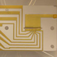 Teleportation takes place inside an ion trap made of gold electrodes deposited onto alumina. The trap area is the horizontal opening near the center of the image.