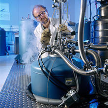 NIST physicist Rand Elmquist fills a cryogenic chamber with liquid helium in preparation for measuring the international standard for electrical resistance—the quantum Hall effect.