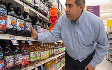 Man selecting grape juice in grocery store