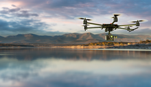 Flying drone over water with mountain landscape in the background
