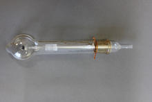 a glass tube with a bulb at one end. there is a glass filament running through the center of the tube that coils on the bulbous end. there is a brass-colored plug at the other end where the tube tapers to a smaller straight tube