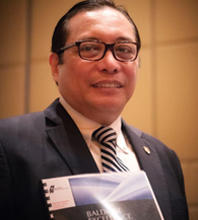 Photo of Luis Calingo holding the Baldrige Excellence Framework.