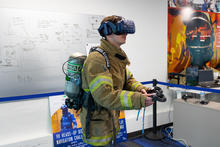 This image shows a man in firefighter uniform wearing a VR headset