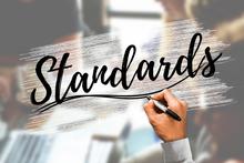 decorative image with a hand writing the word standards