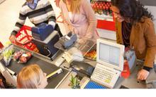 Photo of individuals at a checkout counter in grocery store