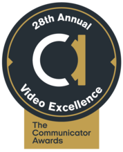 black circle. big white and gold lowercase a in the middle. Around the edges: 28th annual video excellence in white. Gold box at bottom that includes black words: The Communicator Awards