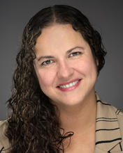 woman headshot with curly brown hair