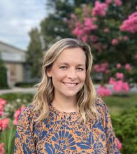 blonde woman in front of pink flowers