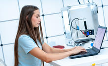 Woman programming at computer with instrument in background
