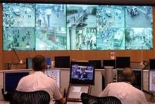 Two men looking at screens above them. 