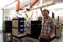 man in lab next to laboratory instruments