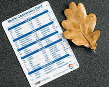 NIST unit conversion card ruler measures an autumn oak leaf