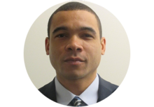 Headshot of Justin Tchabo, a man with short hair, wearing a suit and tie.