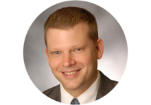 Professional headshot of Michael Epley, a man with short blonde hair, smiling, wearing a suit and tie. 