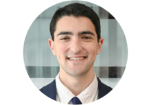 Professional headshot of Ben Hayum, a young man with short black hair, wearing a suit and tie, smiling.