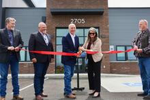 Gov. Gianforte (center left) and DLI Commissioner Sarah Swanson (center right) cutting the ribbon on a new state-owned facility in Helena 