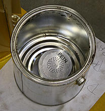 Test container of an odor-releasing material hiding in a pail waiting to be discovered.
