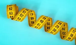 blue backgrond with a coiled yellow metric tape measure