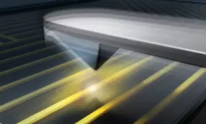 Illustrated metallic tip of an atomic force microscope hovers over a microcircuit on a chip.