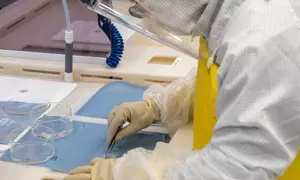 A woman wearing protective gear works in the NIST nanofabrication facility