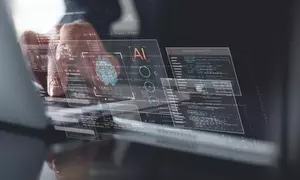 A person types on a laptop behind floating translucent graphics related to AI, computer code and a brain scan. 