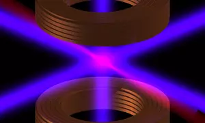 Laser light in pink and purple crosses between two cylindrical shapes on a black background. 