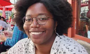 Profile picture of a woman in a black and white collared top.