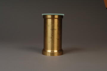 Brass volumetric standard that says "litre" on front, with glass cover on the top