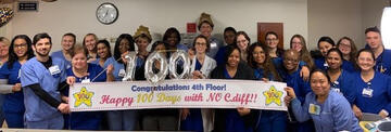 Duke Raleigh Hospital staff showing a sign that says celebrate 100 days with no instances of the hospital-acquired infection&nbsp;Clostridium difficile, also known as C.diff.