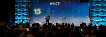Speaker standing on the main stage at the NICE Conference