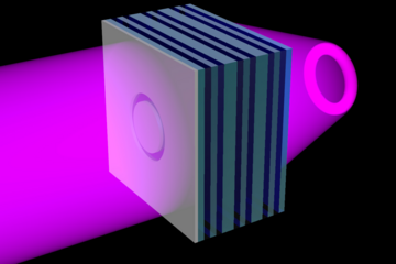 A schematic shows an opaque sheet with a ring-shaped opening layered over the left side of the metamaterial flat lens. Ultraviolet light shines from the left side of the metamaterial, through the ring-shaped opening, to the other side of the lens, where it's projected as a 3D ring of light.