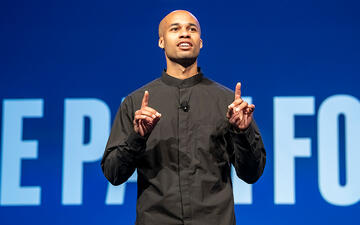 Tucker Bryant speaks on a stage in front of an audience.