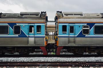 A detailed view of two connected blue and silver train cars on a railway track.