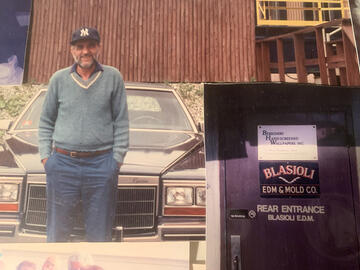 Family photo shows a man in a Yankees cap posing in front of a 1970s-era car. Inset shows sign on door reading: Blasioli EDM & Mold Co.