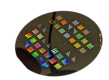 Black disk has multicolored squares and triangles on its surface. 