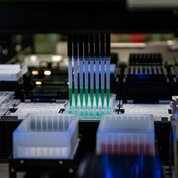Within the NIST Living Measurement Systems Foundry, an automated liquid handler transfers samples between 96-well plates for testing.