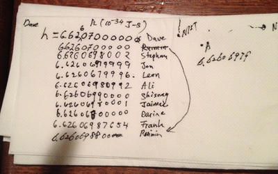 Image of a napkin that has written on it the names of researchers involved in the project and their guesses for the value of Planck's Constant