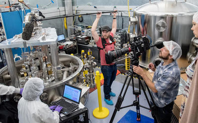 Film crew films a pair NIST researchers operating the NIST Kibble balance