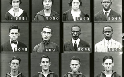 A grid of 12 obviously old photos individuals' face from their shoulder up.  In each photo is a four-digit code for that person