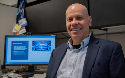 Apostol Vassilev poses for a photo with a computer monitor in the background.