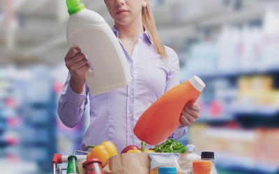 Consumer examining bottle labels in grocery store
