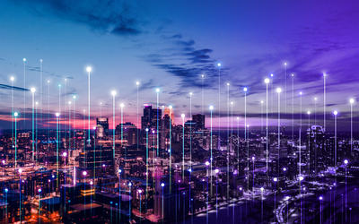 Stylized network connection points rise above a city skyline at sunset.