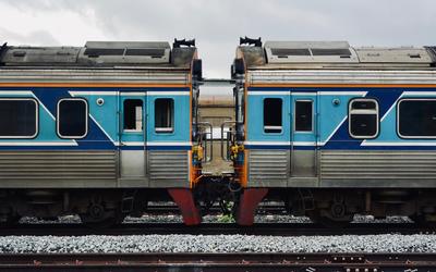 A detailed view of two connected blue and silver train cars on a railway track.