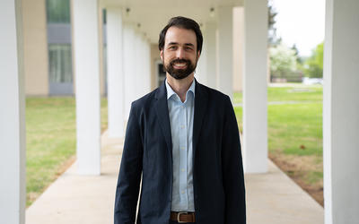 Corey Stambaugh poses smiling outdoors on the NIST campus.