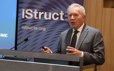 Glenn Bell speaks at a podium with an IStructE banner behind him. 