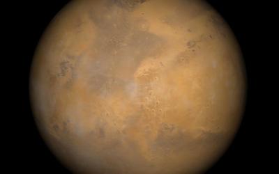 Color-enhanced photo of Mars shows the planet with patches of orange and brown. 