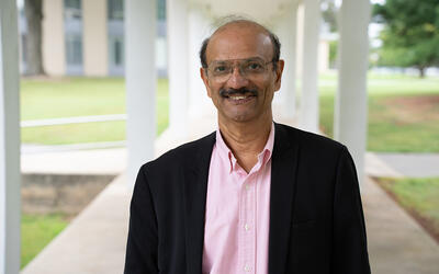 Ram Sriram poses smiling for a head shot outdoors on the NIST campus.