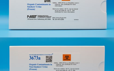 Two white cardboard boxes with white labels that contain blue text that reads  "Organic contaminants in smokers' urine"  One box displays Standard reference material 3672a and other 3673a
