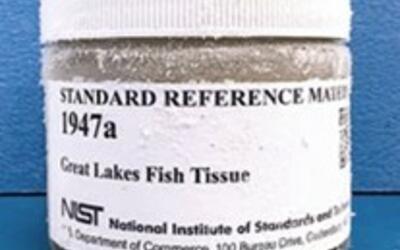 glass jar container with a white cap and white label that reads "Standard Reference Material 1947a great lakes fish tissue"
